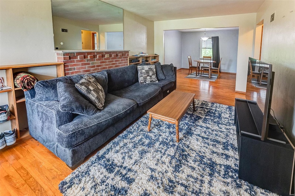 living area with visible vents and wood finished floors