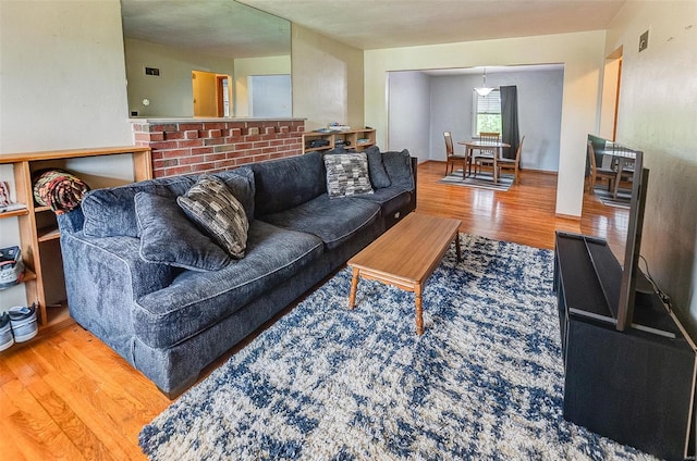 living area with visible vents and wood finished floors