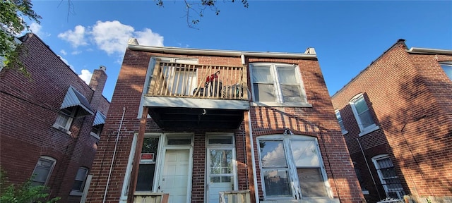 front of property with brick siding and a balcony