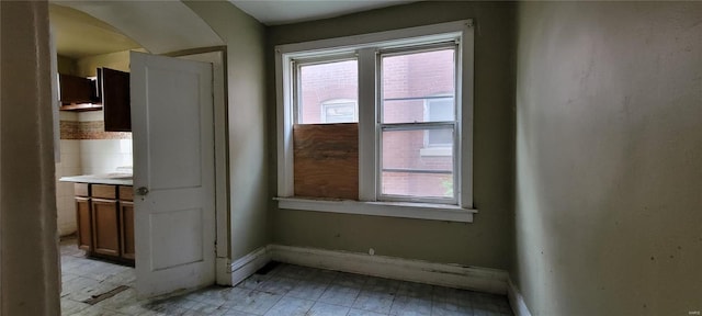 unfurnished room featuring plenty of natural light and baseboards