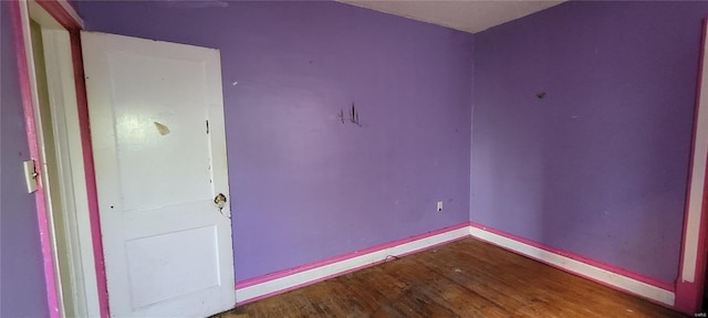unfurnished room featuring baseboards and wood finished floors