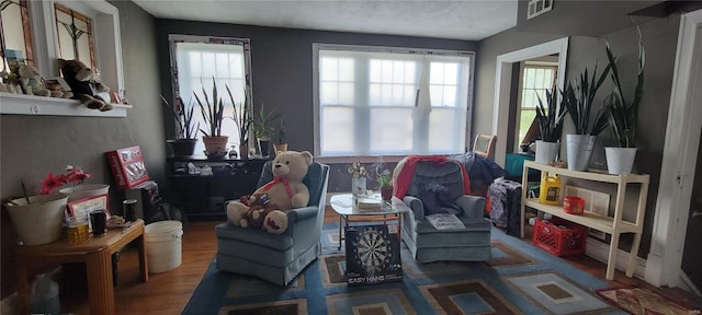 living area with visible vents and wood finished floors