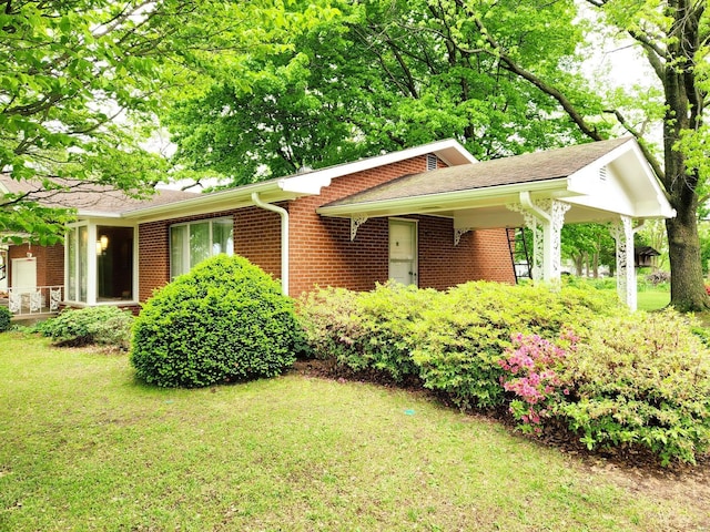 view of front of home with a porch, brick siding, and a front lawn