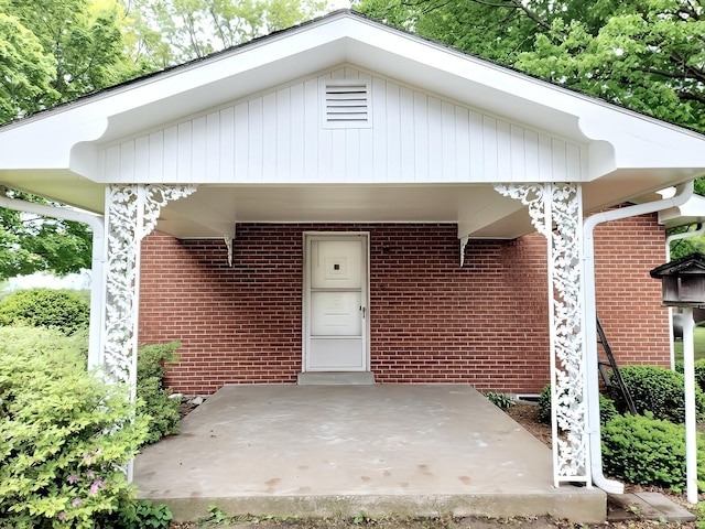 doorway to property with a patio area and brick siding