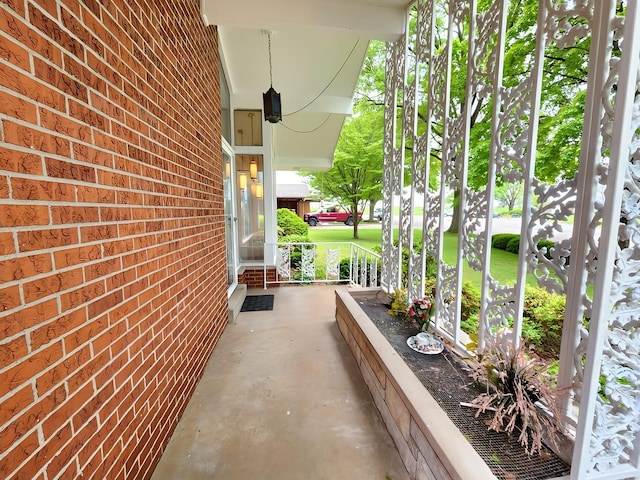 view of property exterior with a porch and brick siding