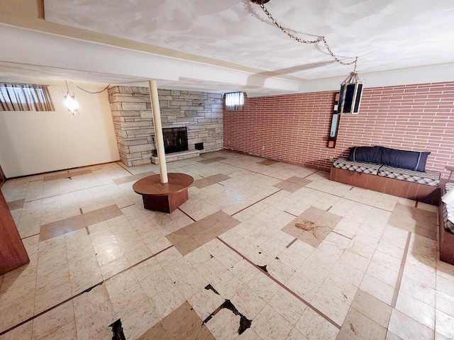 basement with baseboards, tile patterned floors, and a large fireplace
