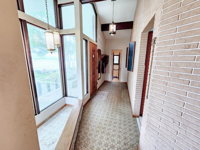 hall with baseboards and high vaulted ceiling