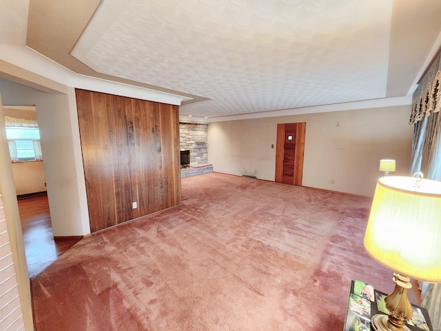 unfurnished living room with carpet and a fireplace
