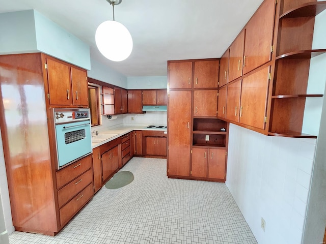 kitchen with open shelves, brown cabinets, and oven