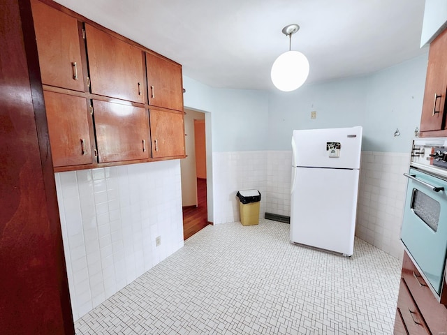 kitchen featuring light countertops, tile walls, brown cabinetry, and white appliances