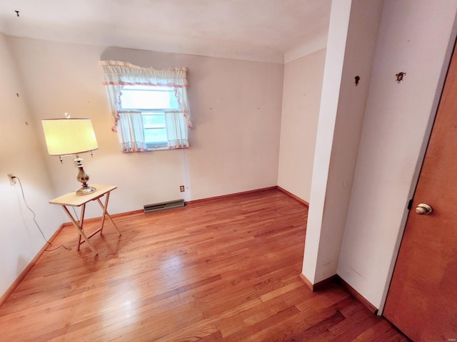 spare room featuring baseboards, light wood-style flooring, and visible vents