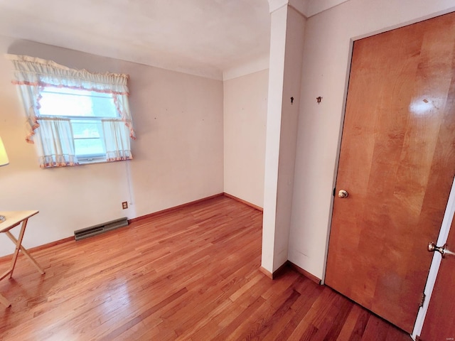 unfurnished room featuring baseboards, wood finished floors, and visible vents
