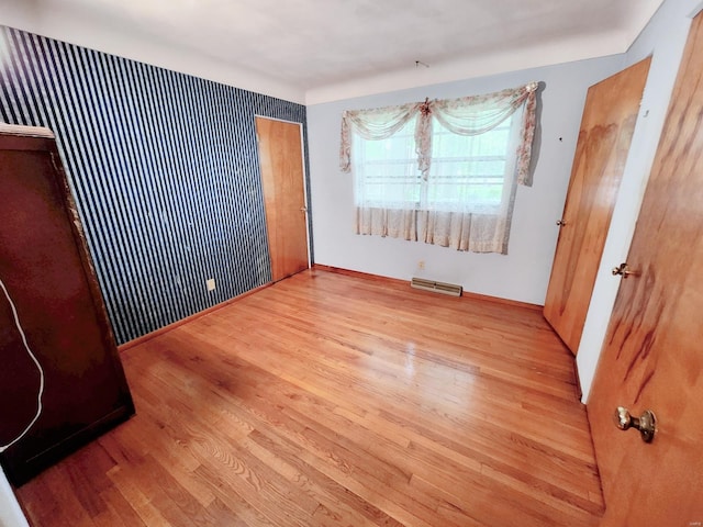 unfurnished bedroom with visible vents, baseboards, and wood finished floors