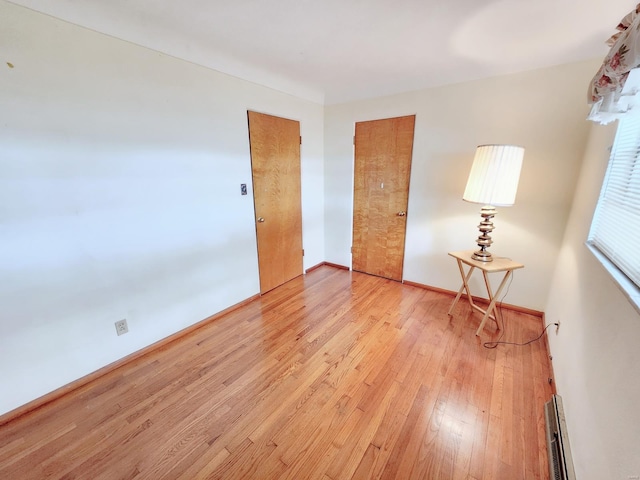 empty room with baseboards and light wood finished floors
