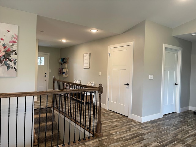 corridor with baseboards, dark wood-style floors, an upstairs landing, and recessed lighting
