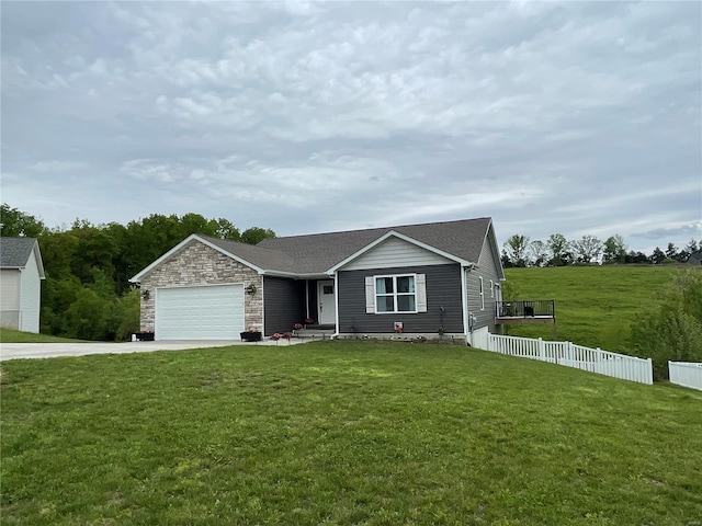 ranch-style home featuring driveway, fence, a garage, stone siding, and a front lawn