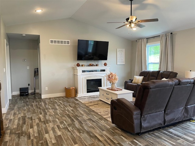 living area featuring lofted ceiling, baseboards, ceiling fan, visible vents, and wood finished floors