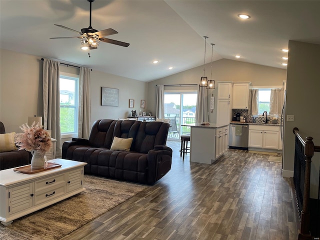 living room featuring a wealth of natural light, dark wood finished floors, vaulted ceiling, and a ceiling fan