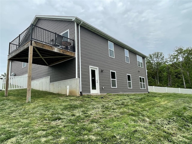 rear view of property with a yard, a deck, and fence