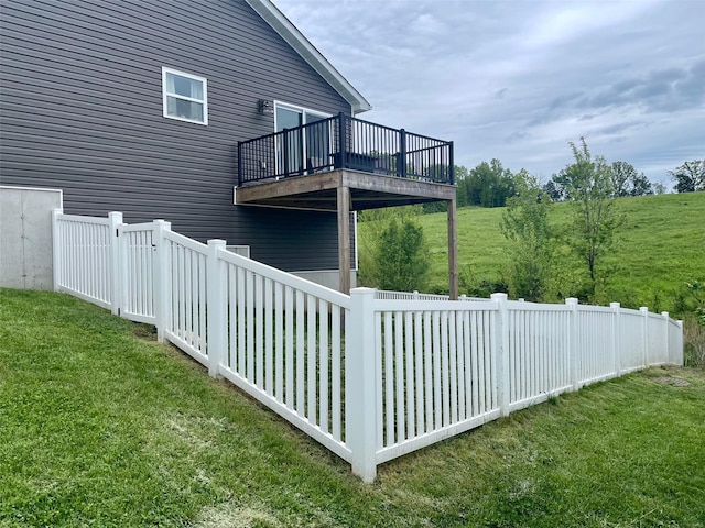 view of property exterior with a yard, fence, and a balcony