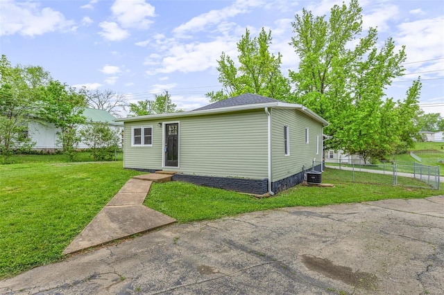 view of front of property with central AC, entry steps, a front lawn, and fence