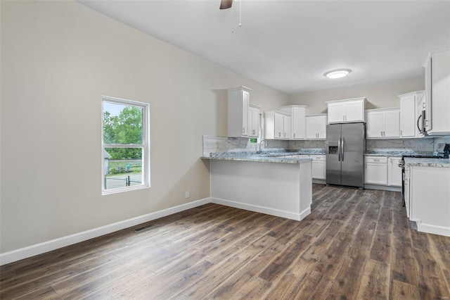kitchen featuring a peninsula, a sink, visible vents, appliances with stainless steel finishes, and decorative backsplash