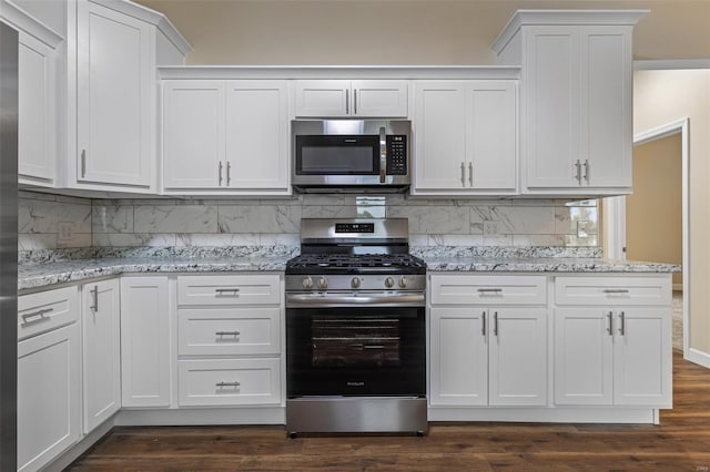 kitchen with stainless steel appliances, backsplash, dark wood-style floors, white cabinets, and light stone countertops