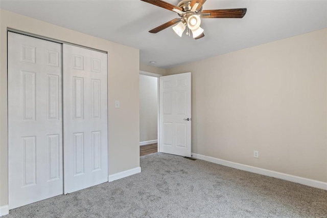 unfurnished bedroom featuring carpet flooring, a closet, baseboards, and ceiling fan