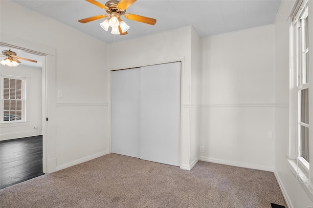 unfurnished bedroom with a ceiling fan, baseboards, carpet, and a closet
