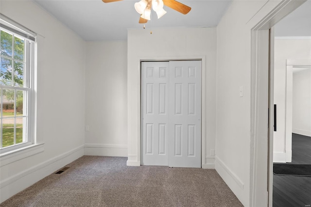 unfurnished bedroom featuring visible vents, carpet, a closet, and multiple windows
