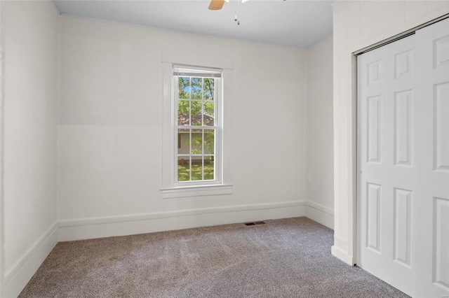 unfurnished bedroom featuring carpet flooring, a ceiling fan, baseboards, visible vents, and a closet