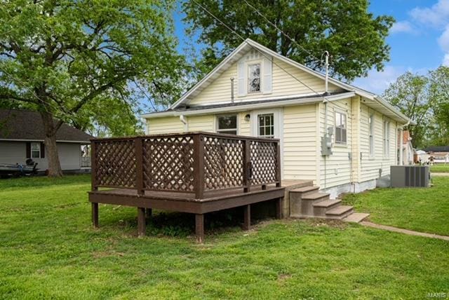 rear view of house featuring a lawn and a deck