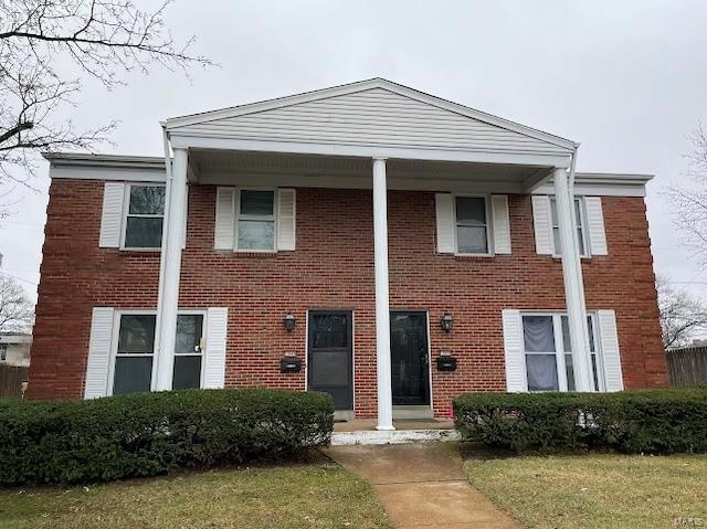 greek revival house featuring brick siding