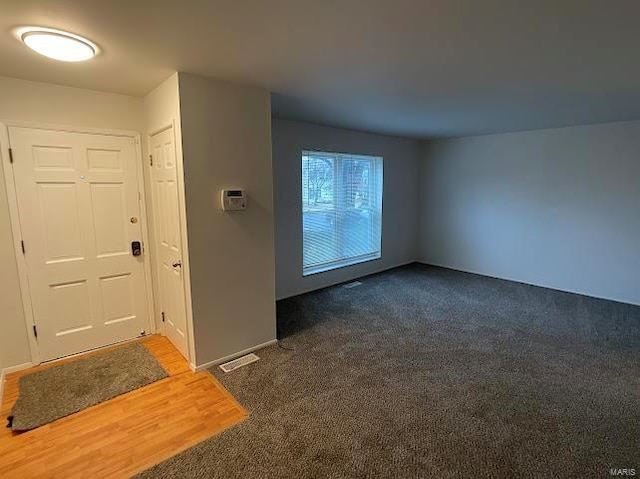 interior space featuring dark colored carpet and visible vents