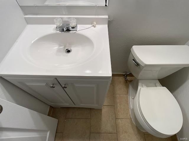 bathroom with toilet, tile patterned floors, and vanity