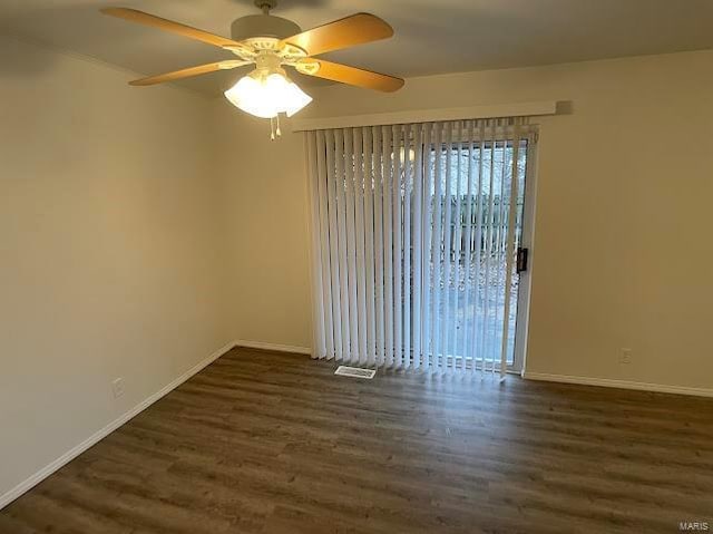 spare room featuring baseboards, a ceiling fan, wood finished floors, and visible vents