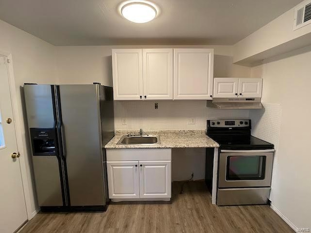 kitchen with white cabinets, a sink, stainless steel appliances, wood finished floors, and visible vents