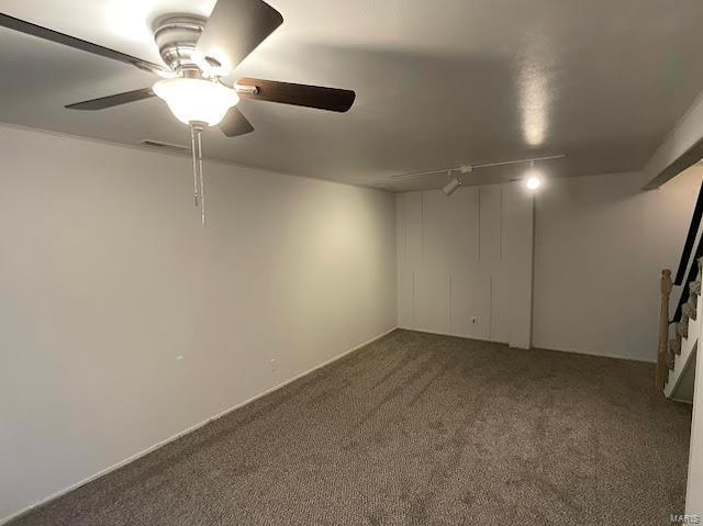 interior space with ceiling fan and dark carpet