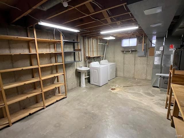 below grade area featuring washer and clothes dryer, a sink, and electric panel