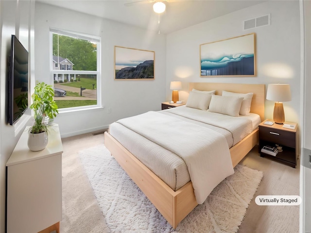 bedroom featuring baseboards, visible vents, and wood finished floors