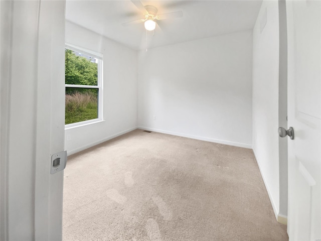 spare room featuring a ceiling fan, baseboards, and carpet