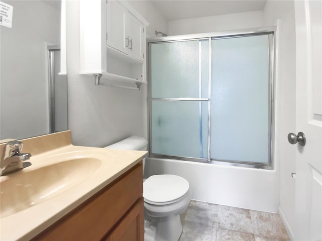 bathroom featuring toilet, vanity, and shower / bath combination with glass door