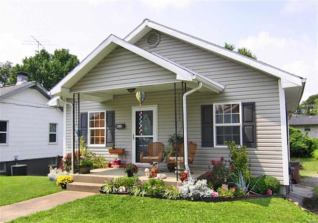 bungalow with a porch and a front lawn