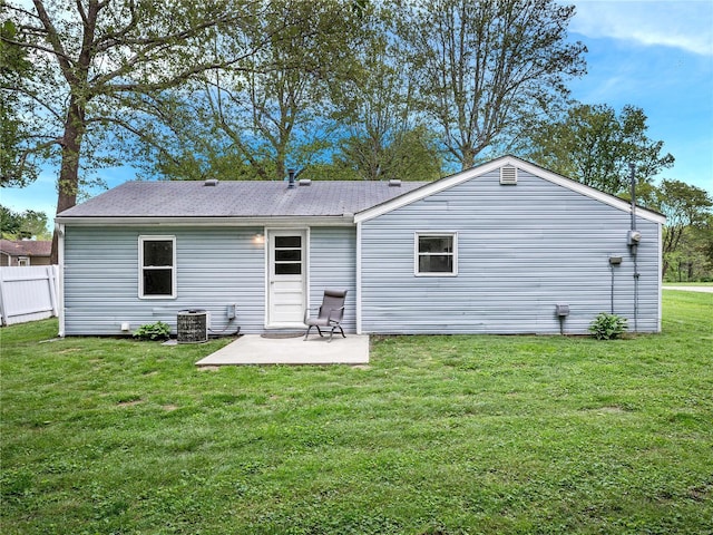 back of property with a yard, a patio area, central air condition unit, and fence