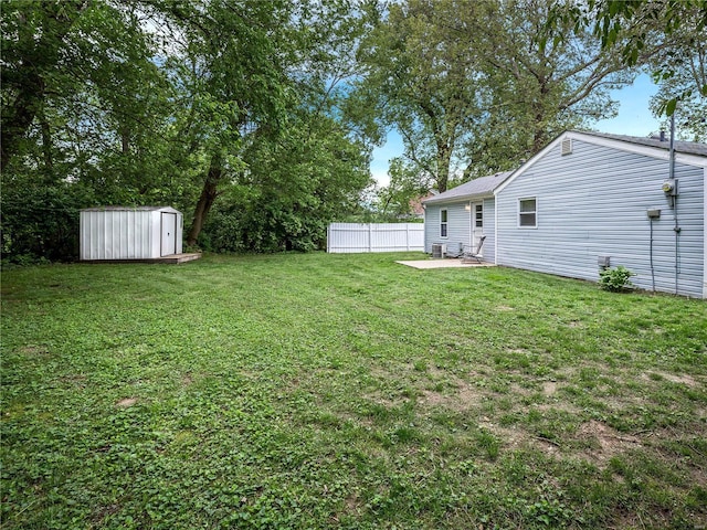 view of yard featuring an outdoor structure, fence, a patio area, and a shed