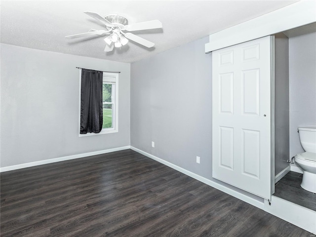 unfurnished bedroom with dark wood-style floors, baseboards, and ceiling fan