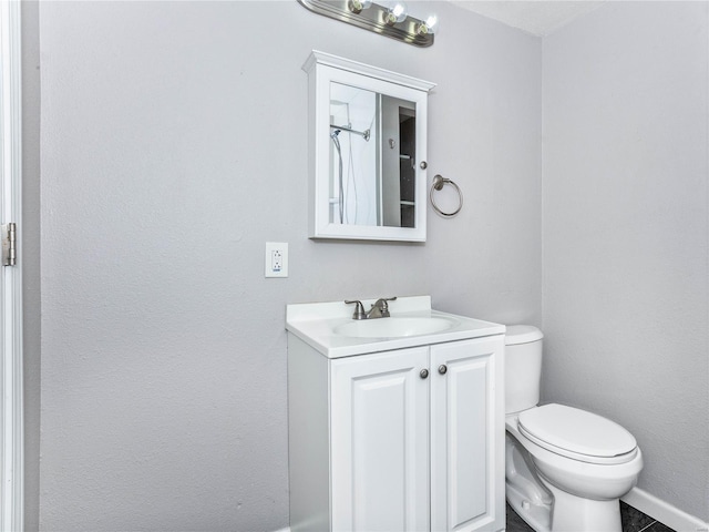 bathroom featuring vanity, toilet, and baseboards