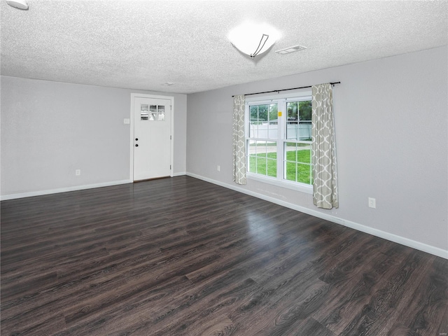 unfurnished living room featuring a textured ceiling, dark wood-type flooring, and baseboards