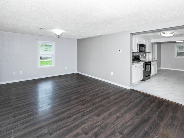 unfurnished living room with a textured ceiling, dark wood-type flooring, and baseboards