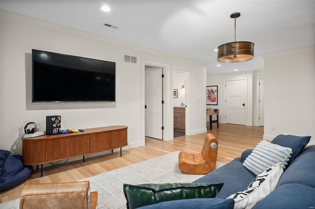 living area featuring visible vents, light wood-style flooring, and recessed lighting